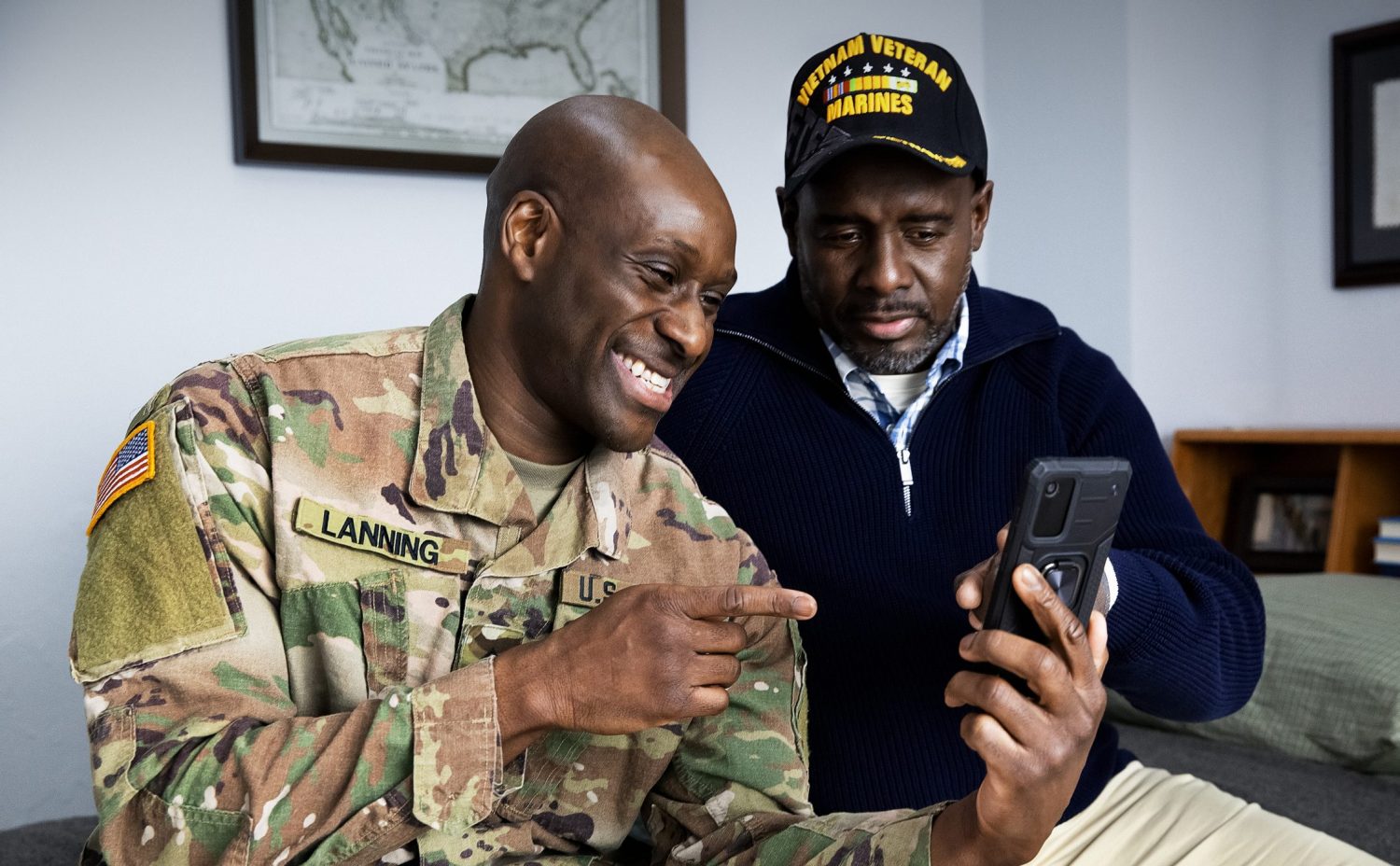 Military member shows a veteran how to use smartphone