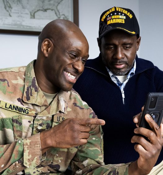 Military member shows a veteran how to use smartphone