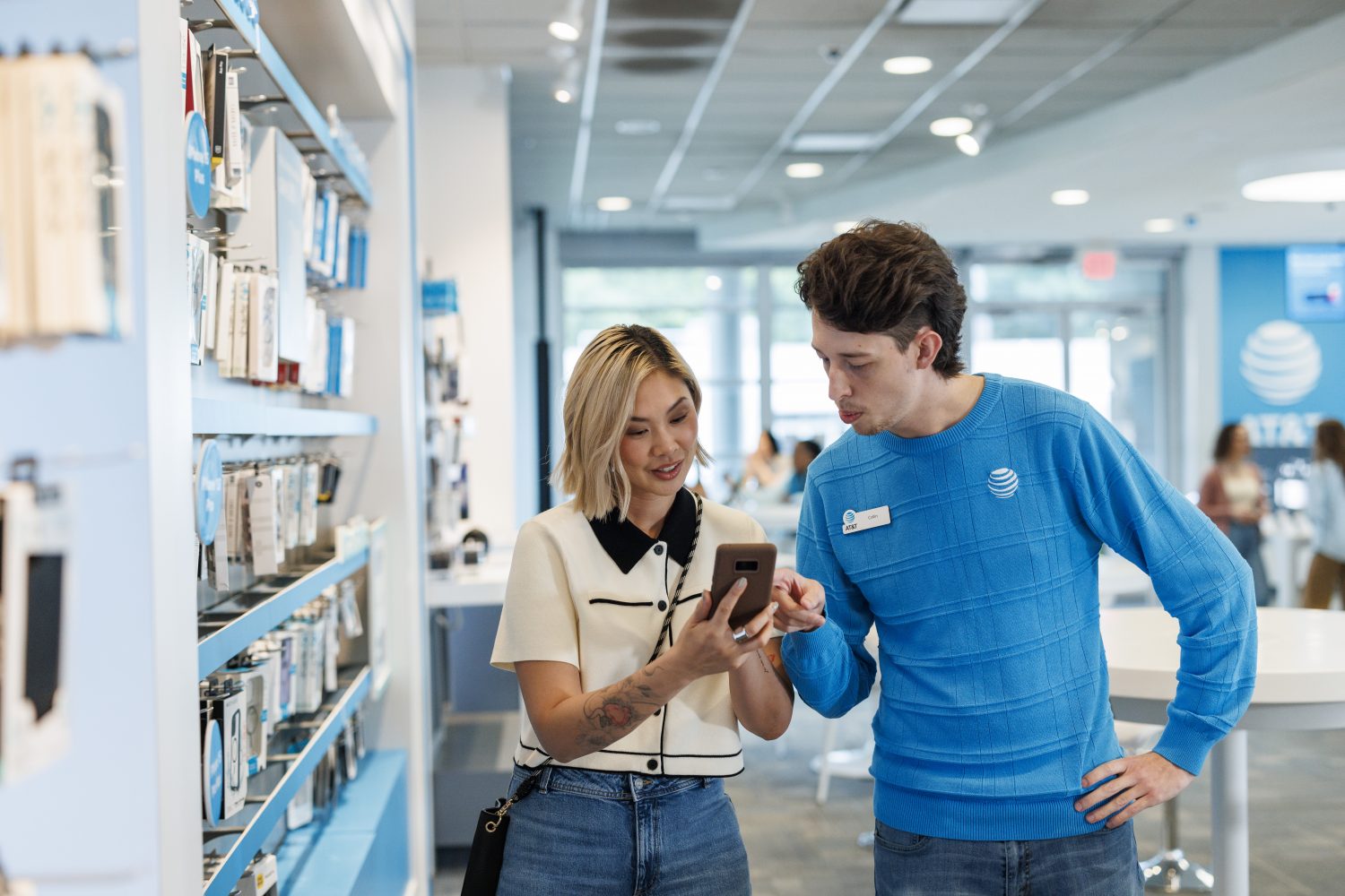 An AT&T employee helps customers at a retail store