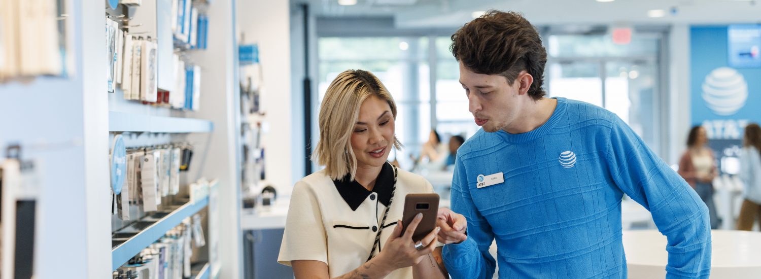 An AT&T employee helps customers at a retail store