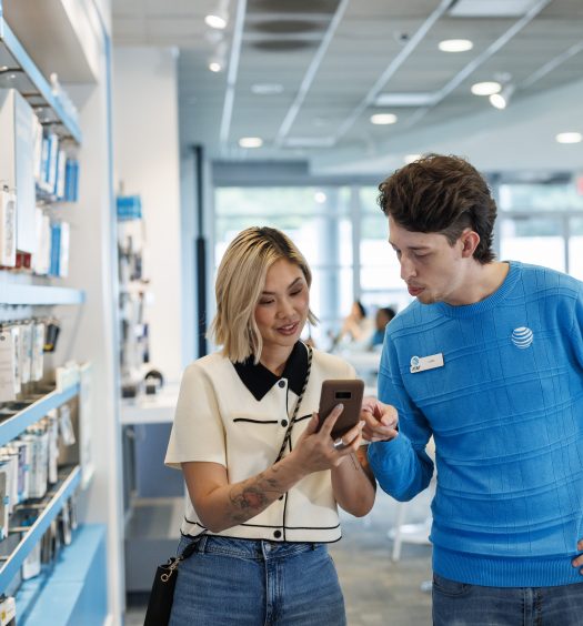 An AT&T employee helps customers at a retail store