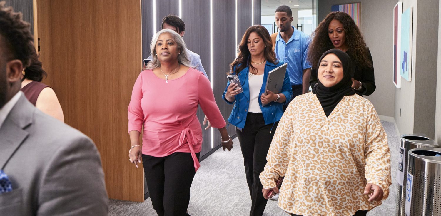 Team members walk through hallway