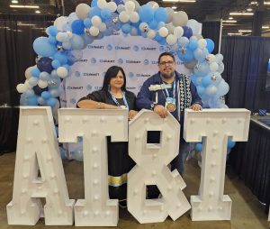 Rachel and Anthony pose behind AT&T sign