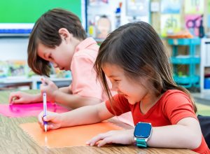 Grade school children in a classroom wearing the AT&T amiGO Jr. Watch (Marketing photo - includes hired actors representing AT&T customers.)