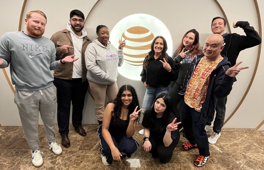 Team members pose in front of the AT&T globe showing off inappropriate work attire