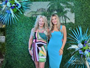 two women in dresses pose for a photo