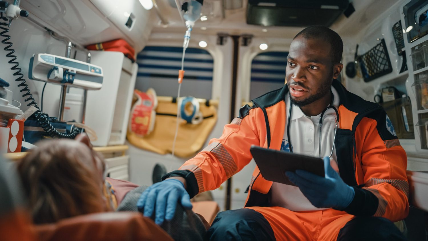 Emergency Medical Technician uses a tablet to help a patient