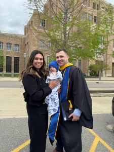 Steve in graduation robe with his wife and child