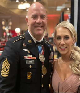 Man in military dress attire with a woman in a pink dress