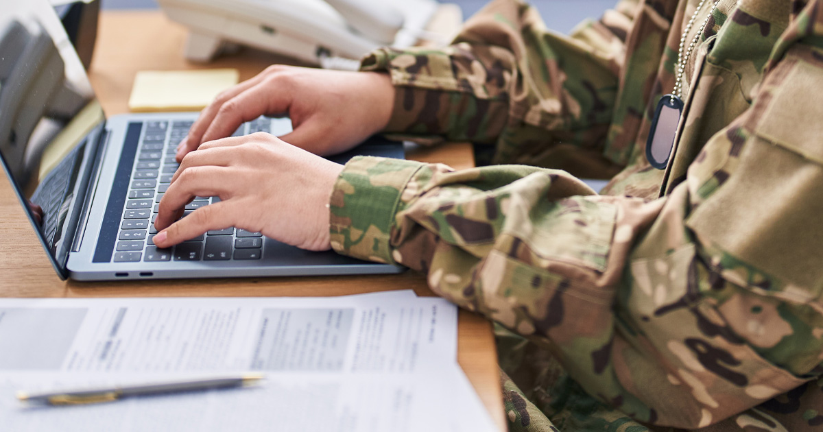Military member works on a laptop